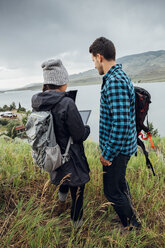 Paar steht am Dillon Reservoir und benutzt ein digitales Tablet, Silverthorne, Colorado, USA - ISF01352