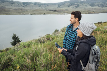 Paar steht am Dillon Reservoir und benutzt ein digitales Tablet, Silverthorne, Colorado, USA - ISF01354