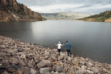 Couple walking on rocks beside Dillon Reservoir, elevated view, Silverthorne, Colorado, USA - ISF01357