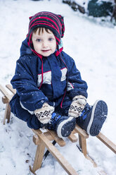 Porträt eines Jungen im Skianzug auf einer Rodelschlittenfahrt - ISF01387