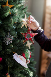 Child putting up Christmas decorations - ISF01396