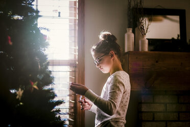 Girl putting up Christmas decorations - ISF01402