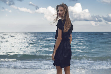 Porträt einer jungen Frau, die am Strand über ihre Schulter blickt, Odessa, Oblast Odessa, Ukraine - ISF01413