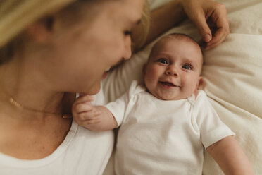 Overhead portrait of woman and baby daughter lying on bed - ISF01427