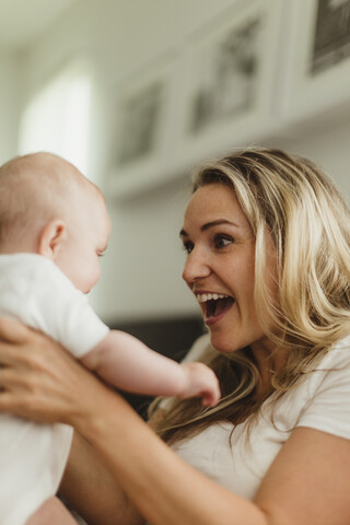 Mutter lächelt ihre kleine Tochter von Angesicht zu Angesicht an, lizenzfreies Stockfoto
