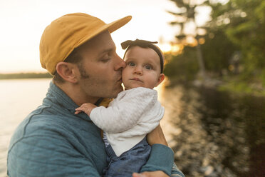 Mann küsst seine kleine Tochter am Seeufer - ISF01441