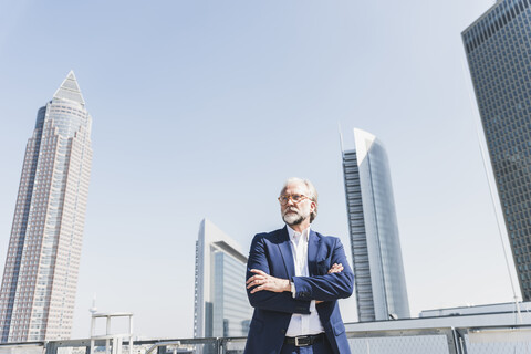 Seriöser reifer Geschäftsmann in der Stadt, der sich umschaut, lizenzfreies Stockfoto