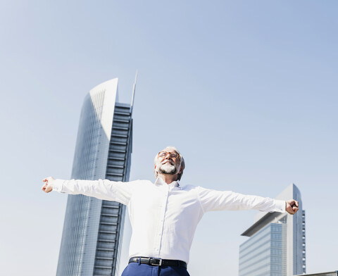 Happy mature businessman cheering in the city stock photo