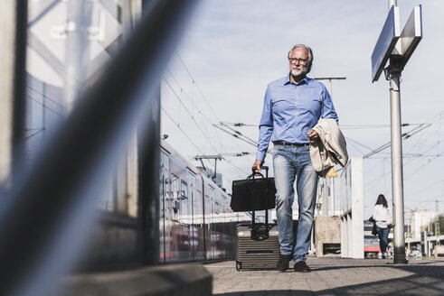 Älterer Geschäftsmann mit Koffer und Aktentasche auf dem Bahnsteig - UUF13735