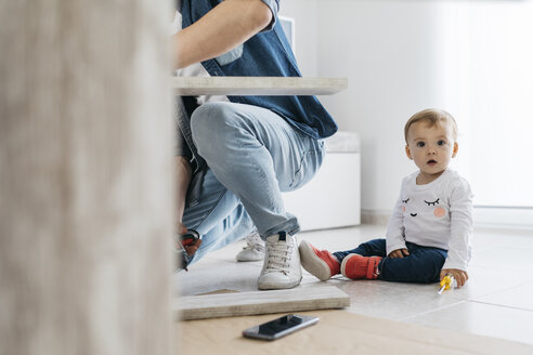 Father and daughter assembling a wooden table at home - JRFF01644