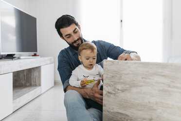 Father and daughter assembling a wooden table at home - JRFF01645