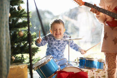 Junge und Schwester spielen Spielzeug Schlagzeug und Gitarre am Weihnachtstag - CUF05743