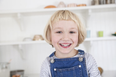 Porträt eines glücklichen Mädchens mit blondem Bob in der Küche - CUF05766