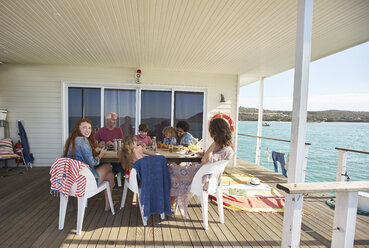 Familie versammelt am Tisch auf dem Sonnendeck eines Hausbootes, Kraalbaai, Südafrika - CUF05833