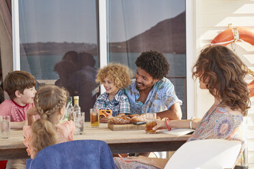 Familie versammelt am Tisch auf dem Sonnendeck eines Hausbootes, Kraalbaai, Südafrika - CUF05834