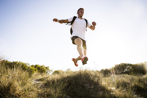 Junger Mann beim Training, Springen in der Luft von Sanddünen, lizenzfreies Stockfoto