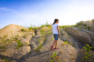 Teenager-Mädchen schaut auf Steinbruch hinunter - CUF05889