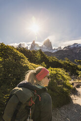 Female hiker hiking near sunlit Fitz Roy mountain range in Los Glaciares National Park, Patagonia, Argentina - CUF05894