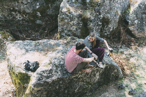 Blick von oben auf zwei Boulderfreunde, die auf einem Felsen sitzen, Lombardei, Italien, lizenzfreies Stockfoto