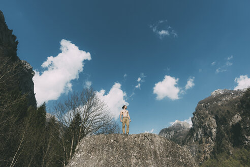 Tiefblick auf einen jungen männlichen Boulderer mit nacktem Oberkörper auf einem Felsen, Lombardei, Italien - CUF05921