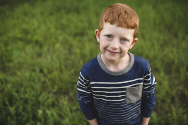 Portrait of red haired boy standing on grass - CUF05964