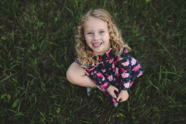 Overhead portrait of blond haired girl sitting on grass - CUF05966