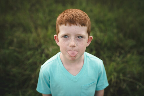 Portrait of red haired boy sticking out tongue - CUF05976