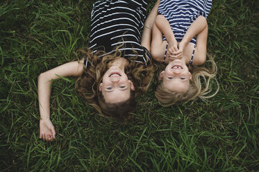 Overhead upside down portrait of girl and her sister lying on grass - CUF05981