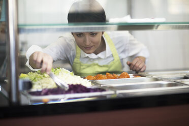 Junge Frau bei der Zubereitung von Speisen in einem Fastfood-Laden - CUF06001