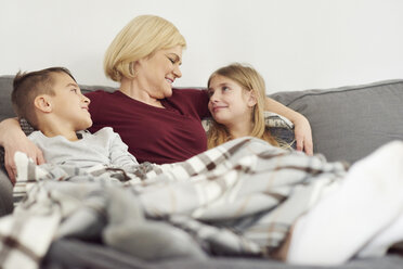 Grandmother and grandchildren relaxing on sofa - CUF06008