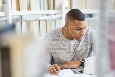 Universitätsstudent, der in der Bibliothek arbeitet - CUF06050