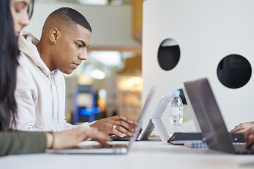 Universitätsstudenten arbeiten mit Laptops und digitalem Tablet zusammen - CUF06062