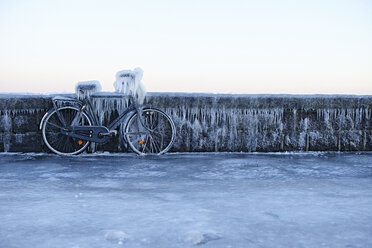 Bicycle leaning against wall, covered in ice - CUF06268