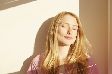 Portrait of young woman, outdoors, in sunlight, eyes closed - CUF06365