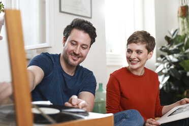 Ein Ehepaar sitzt zu Hause und hört alte Schallplatten - FKF02931