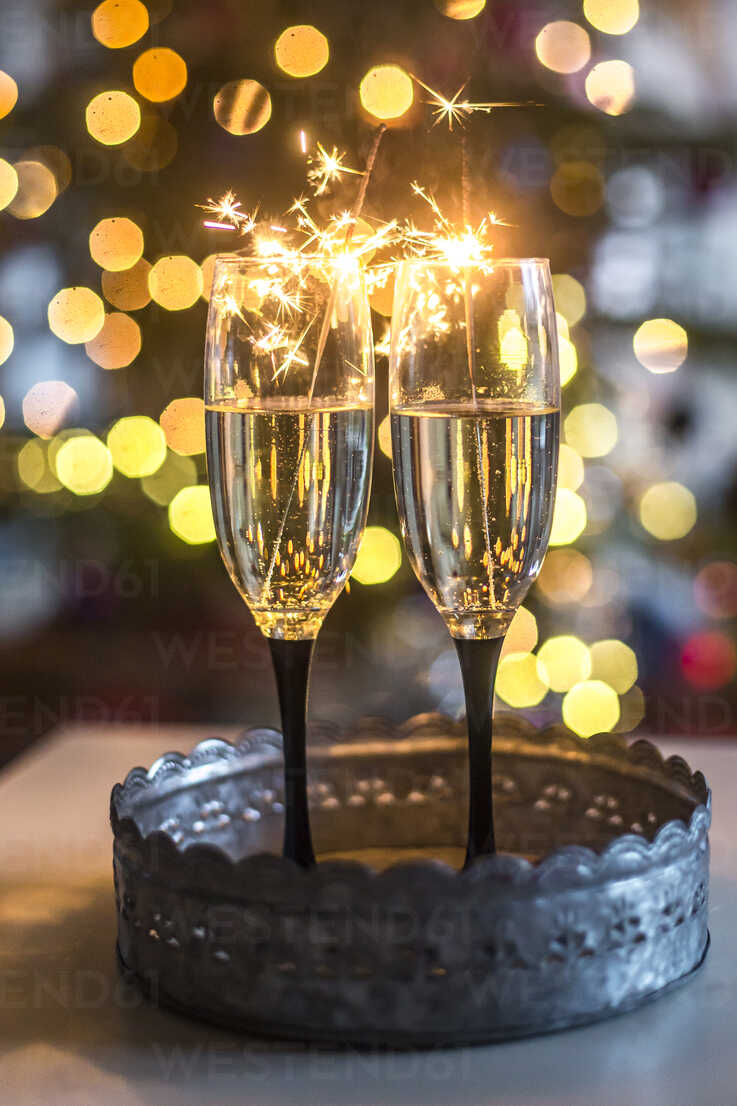 https://us.images.westend61.de/0000940591pw/two-champagne-glasses-and-sparklers-in-front-of-bokeh-SARF03749.jpg