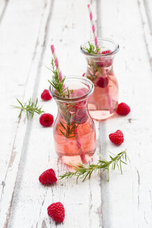 Two glass bottles of homemade raspberry lemonade flavoured with rosemary - LVF06973