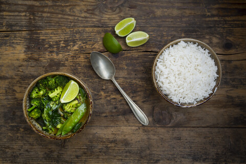 Grünes Thaicurry mit Brokkoli, Pak Choi, Zuckerschoten, Babyspinat, Limette und einer Schale Reis, lizenzfreies Stockfoto