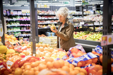 Ältere Frau im Supermarkt, sieht sich frische Produkte an - CUF06421