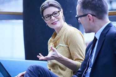 Businessman and woman having discussion in office meeting - CUF06571