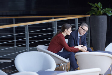 Businesswoman and man having meeting on office balcony - CUF06584