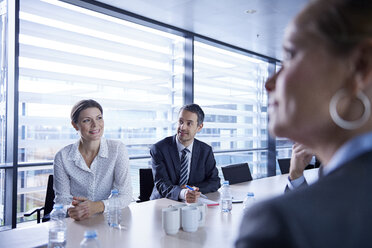 Blick über die Schulter auf Geschäftsfrauen und -männer, die bei einer Bürobesprechung zuhören - CUF06615