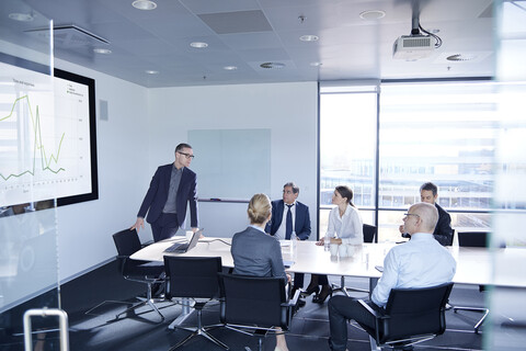 Geschäftsmann, der seinem Team im Sitzungssaal eine Flachbildschirmpräsentation vorführt, lizenzfreies Stockfoto