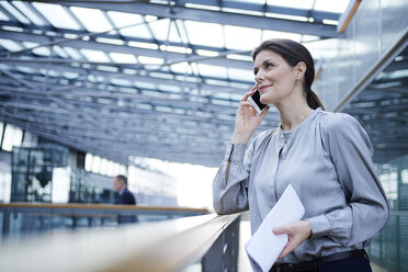 Businesswoman making smartphone call on office balcony - CUF06650