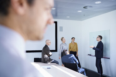Geschäftsmann macht Whiteboard-Präsentation in Konferenzraum Sitzung - CUF06696