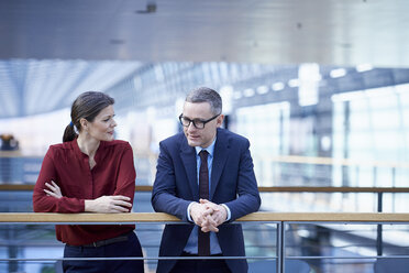 Businesswoman and man talking on office balcony - CUF06700
