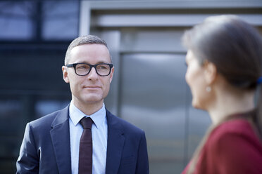 Over shoulder view of businessman approaching woman in office - CUF06704