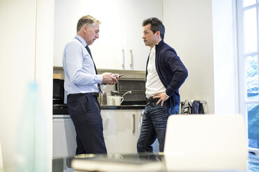 Colleagues in office kitchen having discussion - CUF06724