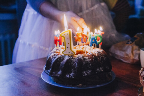 Frau zündet Geburtstagskerzen an, Teilansicht, lizenzfreies Stockfoto