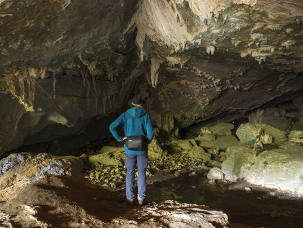 Spanien, Baskenland, Euskadi, älterer Mann betrachtet Felsen in der Baltzola-Höhle - LAF02038